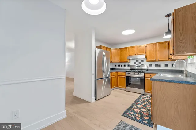 a kitchen with stainless steel appliances a refrigerator and a stove top oven