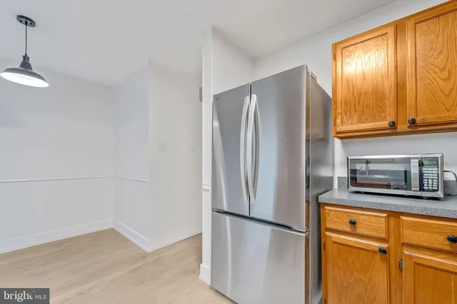 a kitchen with stainless steel appliances granite countertop a refrigerator a microwave and cabinets