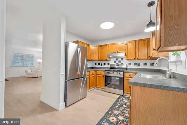 a kitchen with stainless steel appliances granite countertop a refrigerator sink stove microwave and cabinets