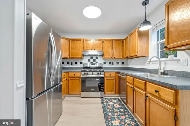 a kitchen with stainless steel appliances granite countertop a refrigerator and a sink