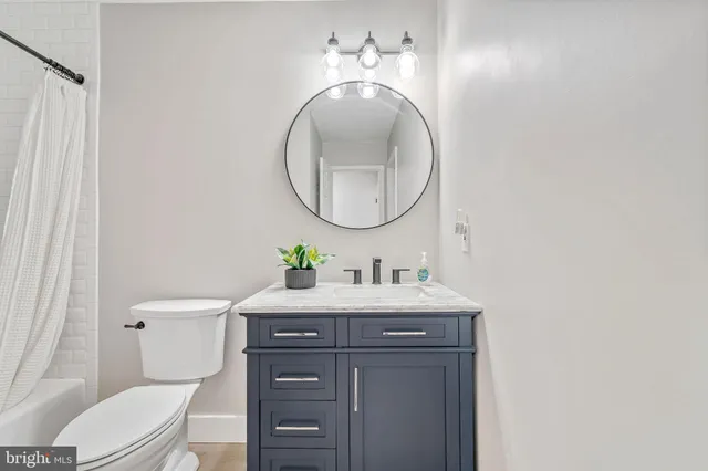 a bathroom with a toilet a sink and mirror