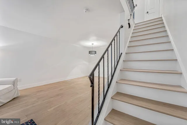 a view of staircase with wooden floor and white walls