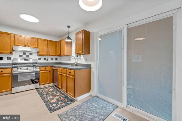 a kitchen with stainless steel appliances granite countertop a stove a sink and a refrigerator