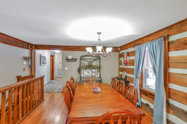 a dining room with furniture a chandelier and wooden floor