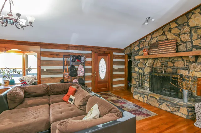 a living room with furniture a flat screen tv and a floor to ceiling window