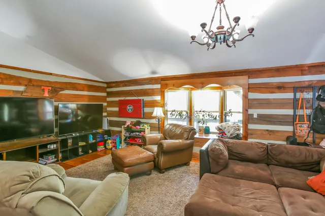 a living room with furniture a large window and a flat screen tv