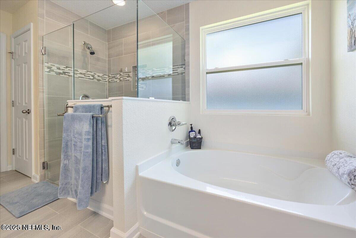 5573 Casavedra Court Jacksonville, FL 32244 - Photo 17 of 34 a bathroom with a bathtub and a shower