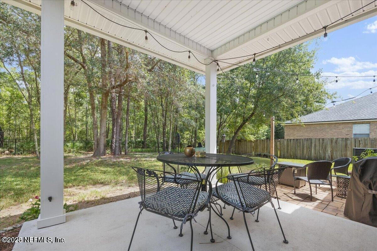 5573 Casavedra Court Jacksonville, FL 32244 - Photo 24 of 34 a view of a patio with table and chairs and floor to ceiling window