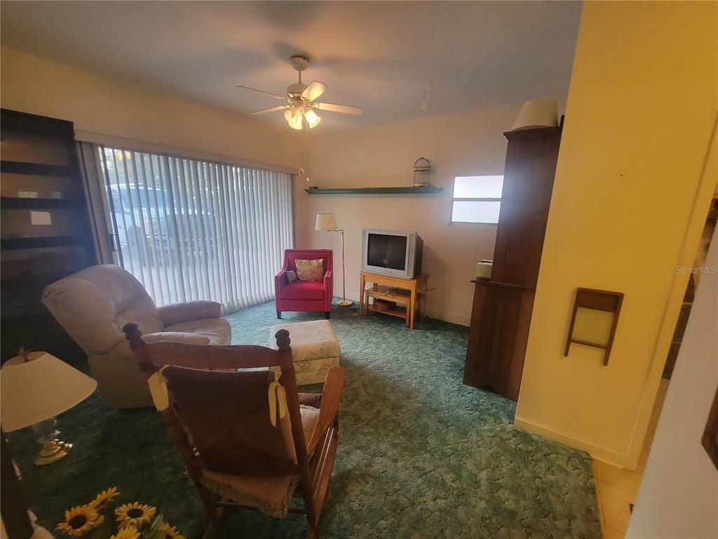 7 Wisconsin Avenue St. Cloud, FL 34769 - Photo 4 of 18 a living room with furniture a flat screen tv and kitchen view