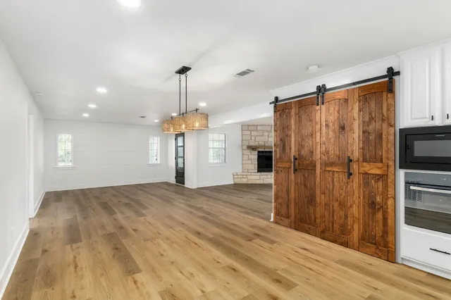 a view of empty room with wooden floor and fireplace