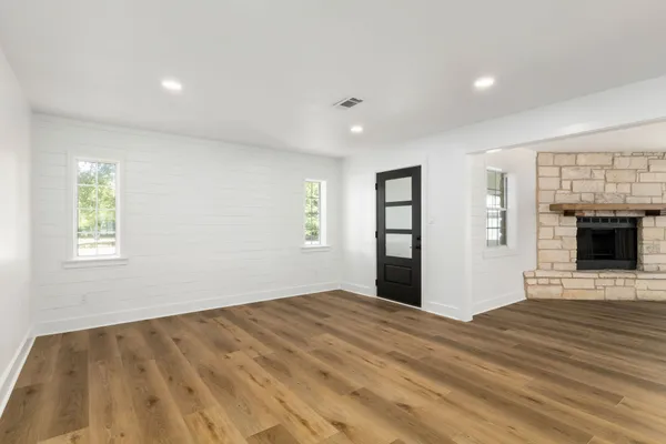 a view of empty room with wooden floor and fireplace