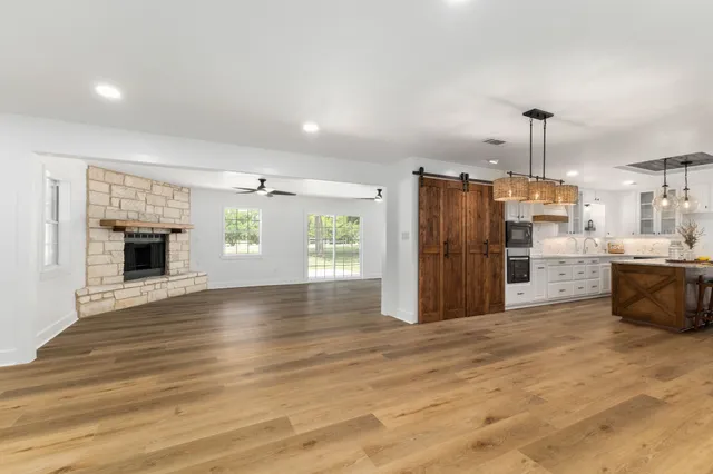a view of a big room with wooden floor and a ceiling fan