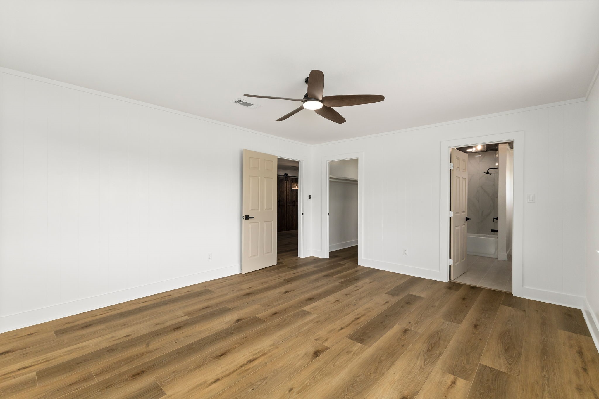 1195 Track Road New Ulm, TX 78950 - Photo 20 of 49 a view of a big room with wooden floor and a ceiling fan
