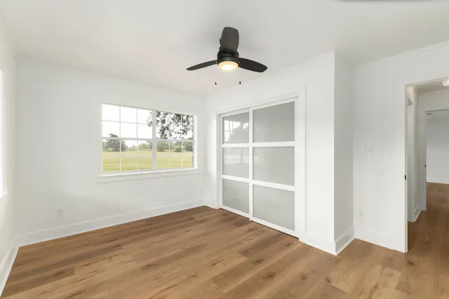 wooden floor in an empty room with a large window