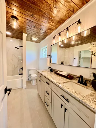 a large bathroom with a granite countertop sink mirror and a shower