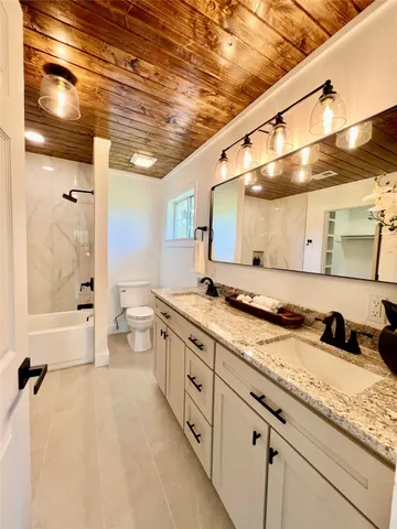a large bathroom with a granite countertop sink mirror and a shower