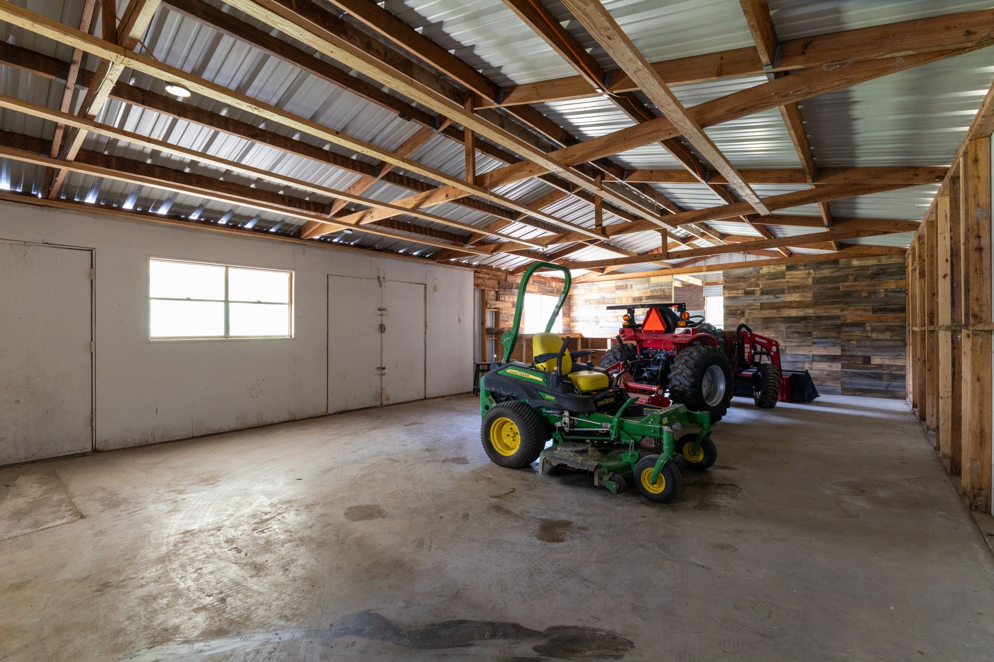 1195 Track Road New Ulm, TX 78950 - Photo 43 of 49 Spacious workshop with high ceilings, ample natural light, and versatile storage options—perfect for projects and equipment storage.