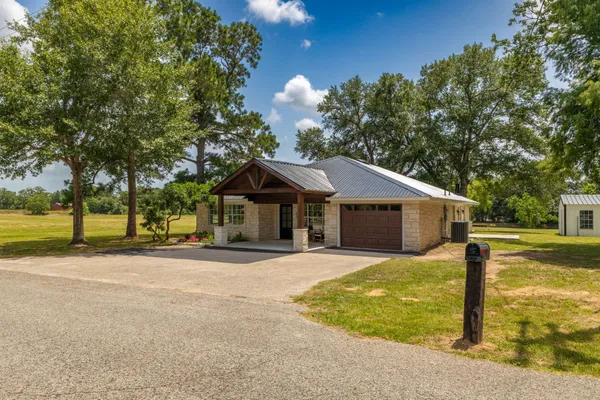 a front view of a house with a yard and trees