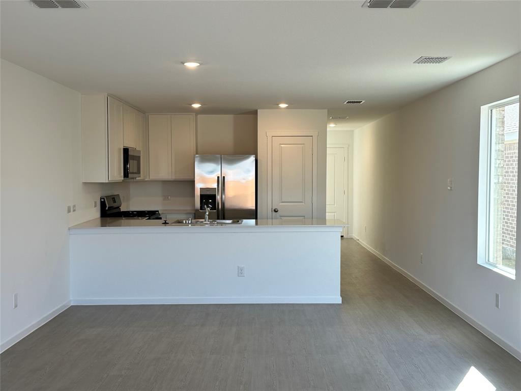 1613 Elliott Road Howe, TX 75459 - Photo 3 of 13 a living room with stainless steel appliances granite countertop couches a flat screen tv and a refrigerator