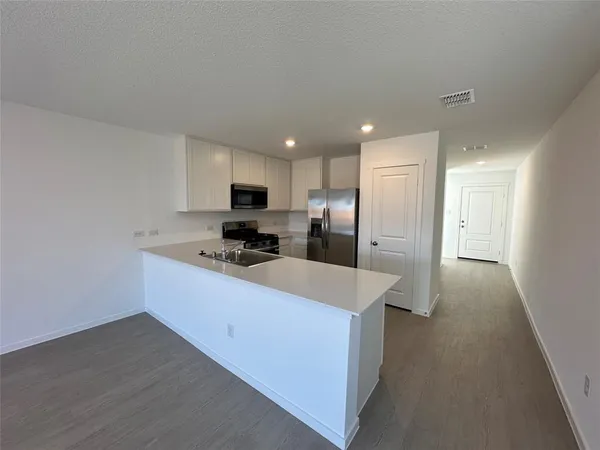 a kitchen with stainless steel appliances a refrigerator sink and microwave