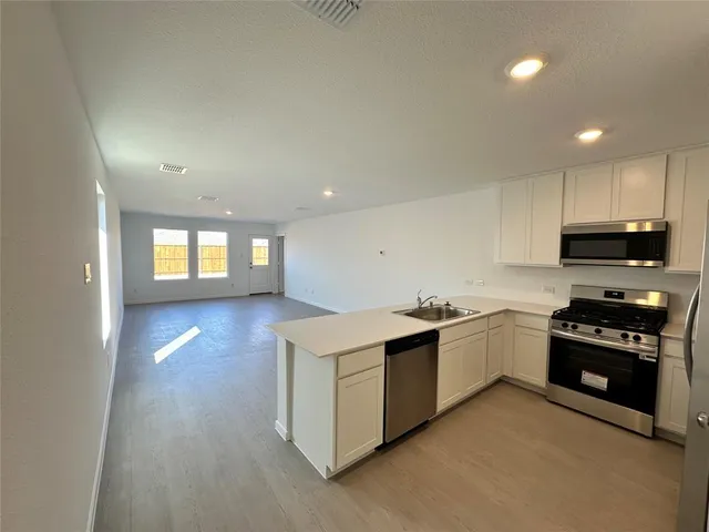 a kitchen with stainless steel appliances granite countertop a stove a sink and a refrigerator