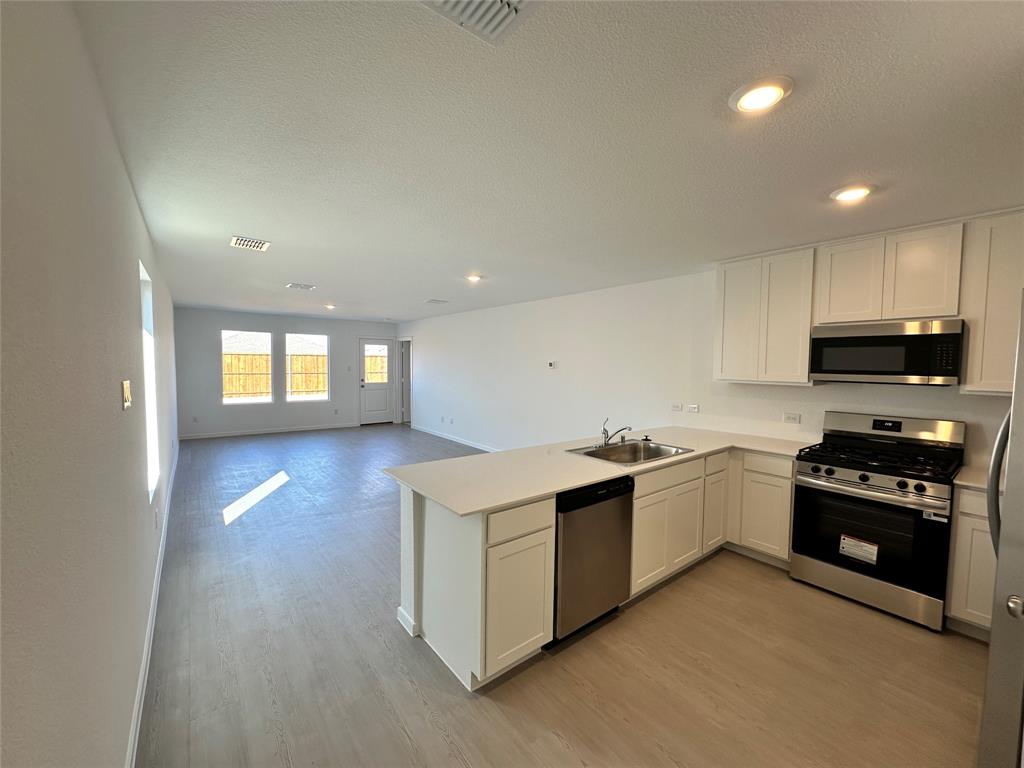 1613 Elliott Road Howe, TX 75459 - Photo 6 of 13 a kitchen with stainless steel appliances granite countertop a stove a sink and a refrigerator