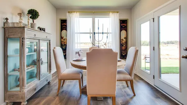 a living room with furniture kitchen view and a large window
