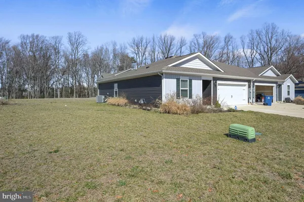 a front view of a house with a yard and trees