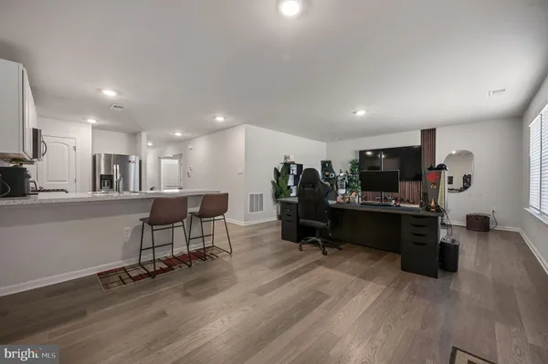 a view of a living room kitchen with furniture and a wooden floor