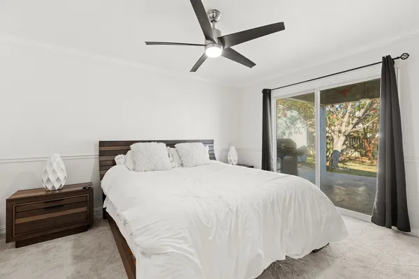 a bedroom with a bed tv and a window