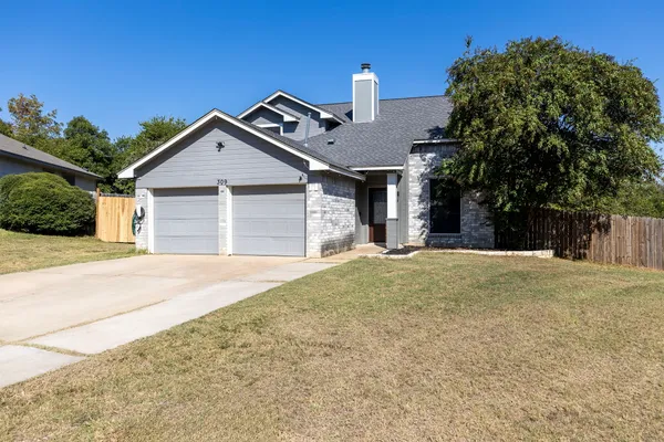 a front view of a house with a yard and garage