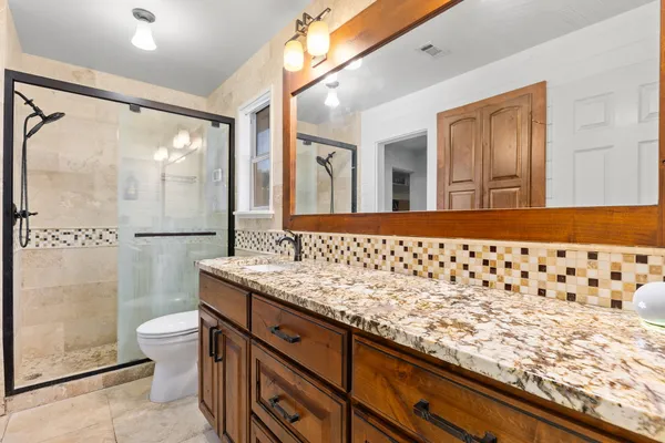 a bathroom with a granite countertop sink and a bathtub