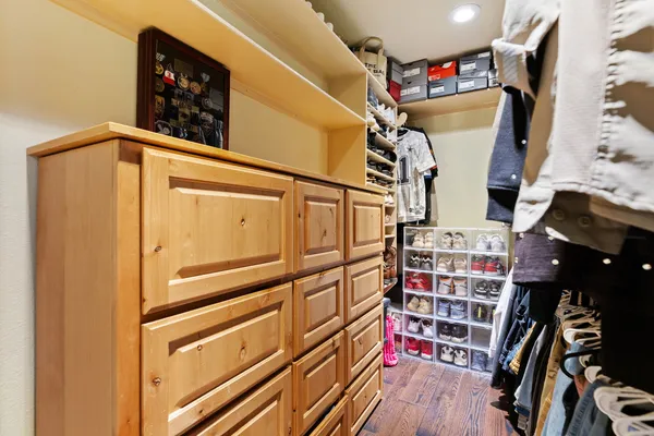 a view of walk in closet with clothes and shoes