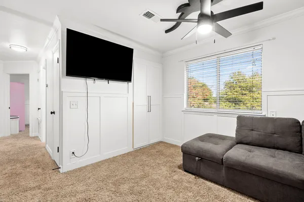 an empty room with a window and ceiling fan