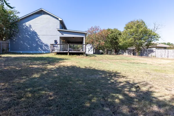 a view of a yard with wooden fence