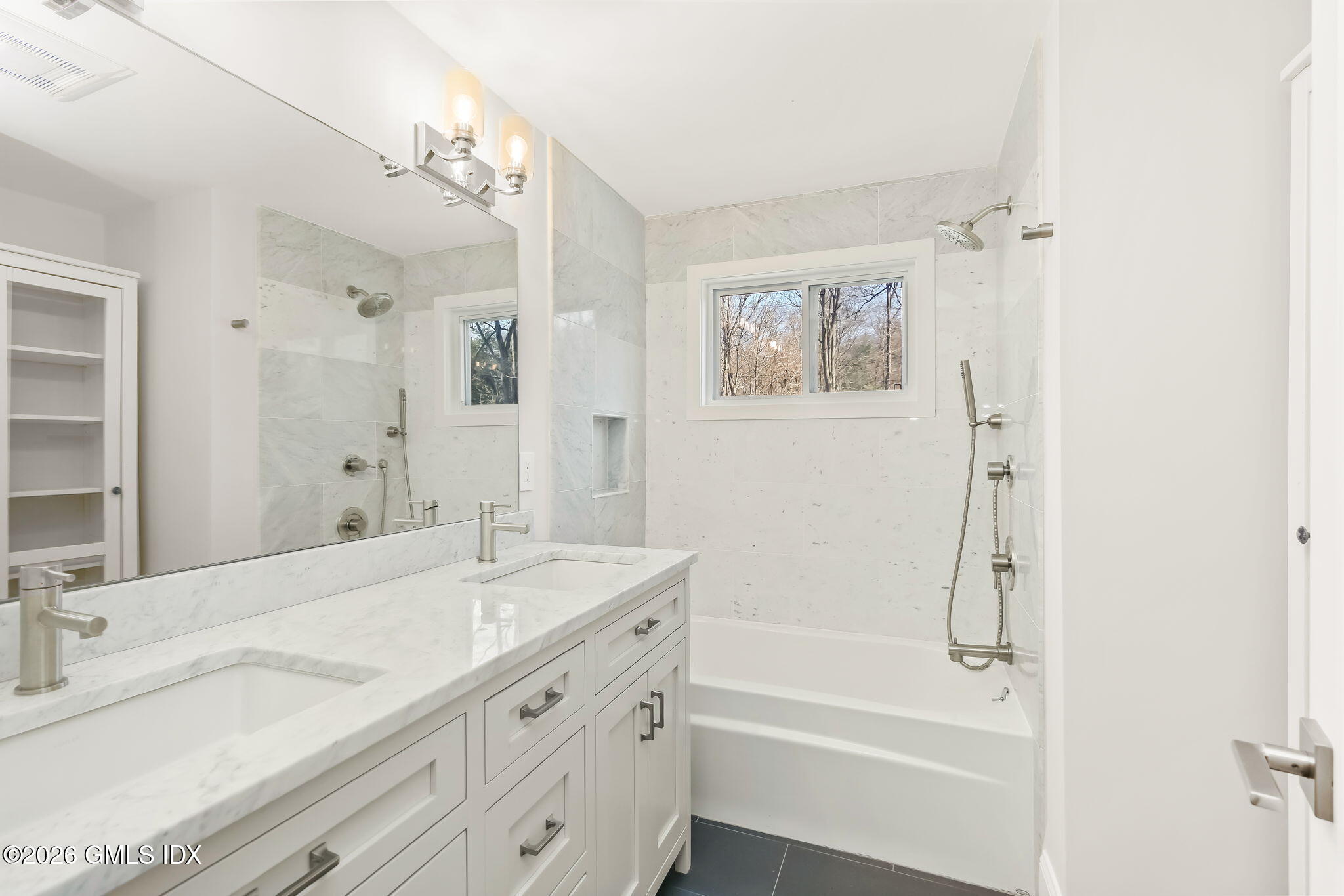 7 Bailiwick Road Greenwich, CT 06831 - Photo 19 of 42 a bathroom with a granite countertop sink a mirror a shower and a bathtub