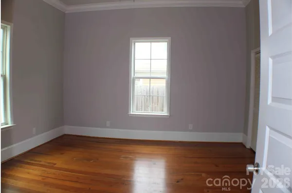 a view of an empty room with wooden floor