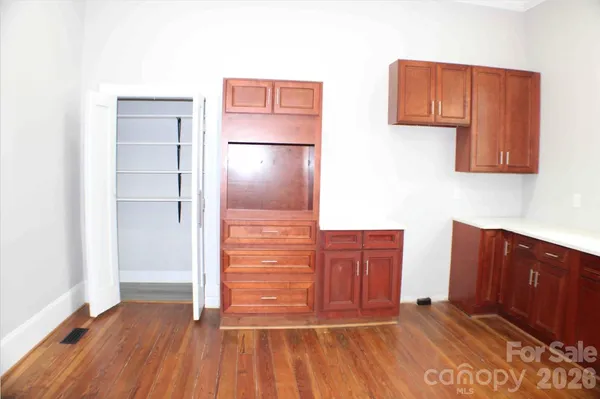 a view of kitchen with wooden floor and cabinets