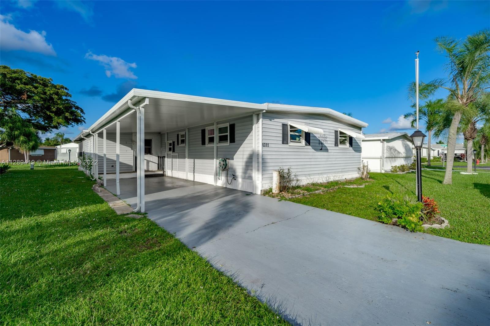 8311 South Street Boca Raton, FL 33433 - Photo 1 of 40 a front view of a house with a yard and porch