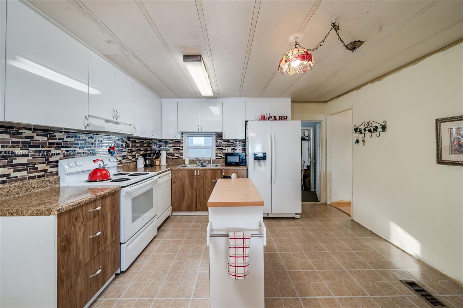 8311 South Street Boca Raton, FL 33433 - Photo 5 of 40 a kitchen with refrigerator and white cabinets