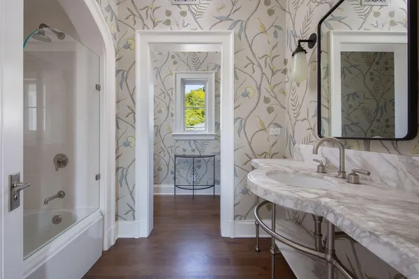 a bathroom with a granite countertop sink a mirror and a bathtub