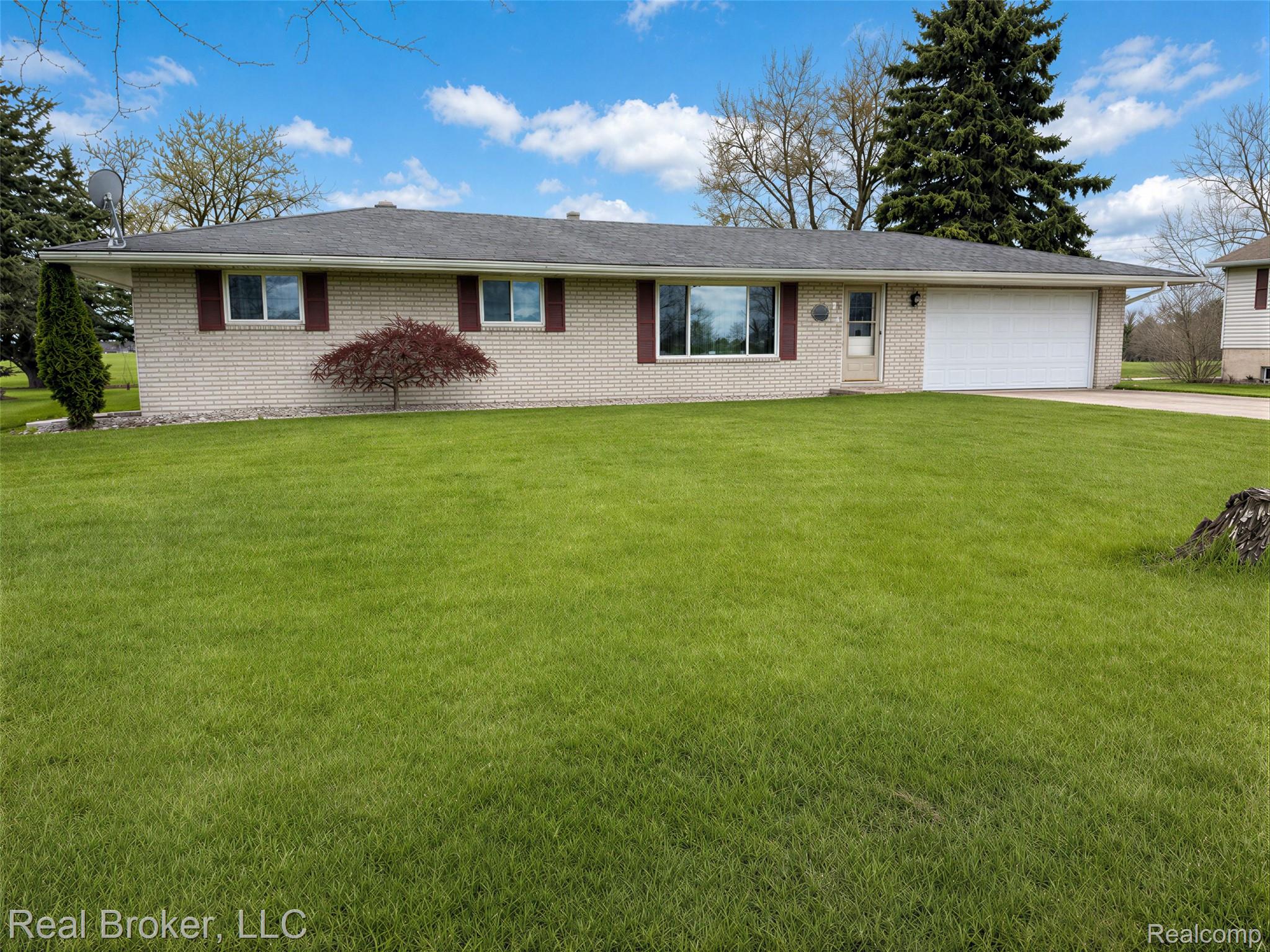 3412 South Reese Road Frankenmuth, MI 48734 - Photo 1 of 17 Ranch-style home featuring an attached garage, a front yard, brick siding, and concrete driveway