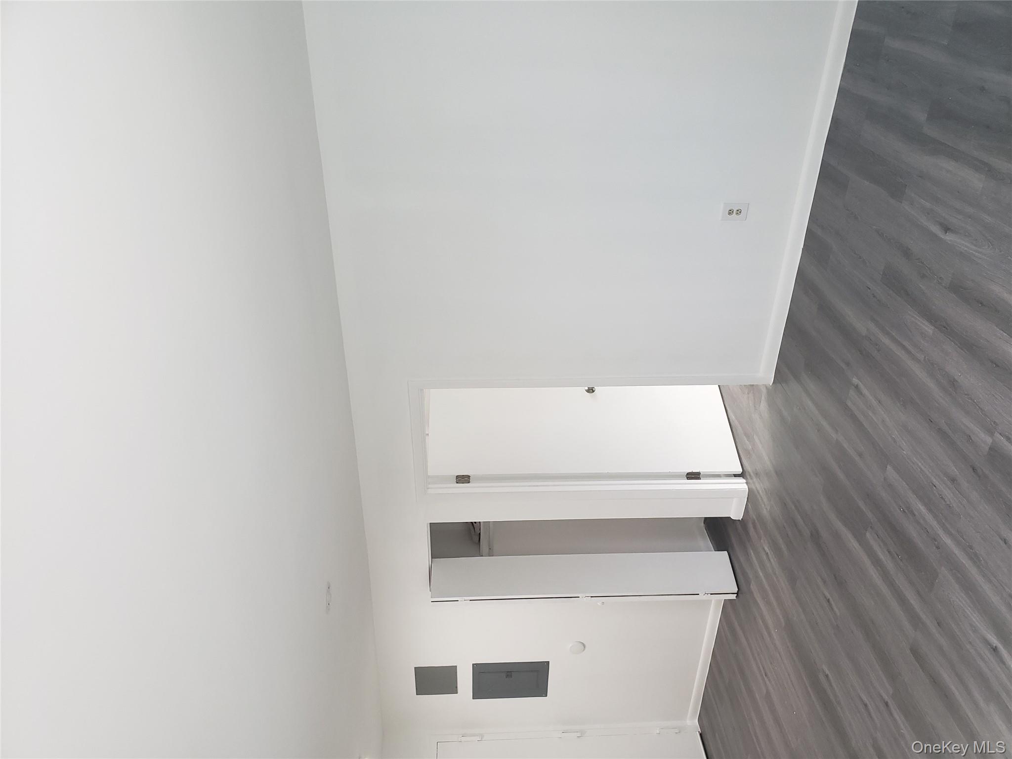 Unfurnished bedroom with dark wood-type flooring, a closet, and electric panel