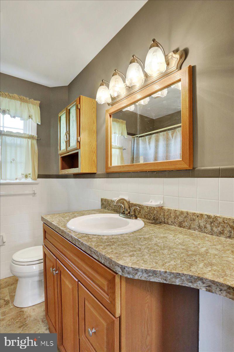 324 Ashley Drive Reading, PA 19607 - Photo 26 of 39 a bathroom with a granite countertop sink a toilet and a mirror
