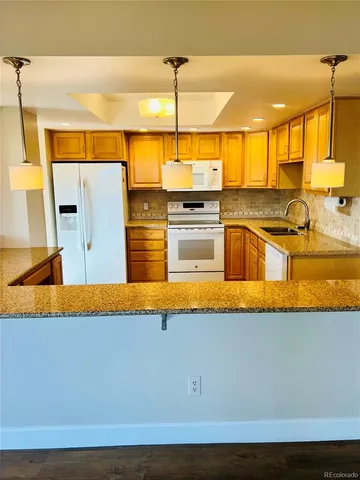 a kitchen with stainless steel appliances granite countertop a sink and a view of living room