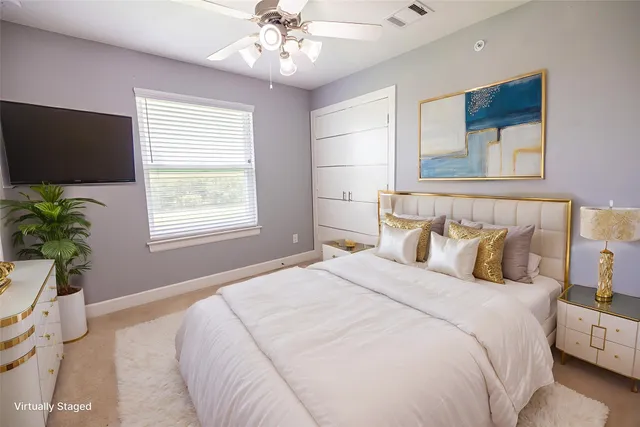 a bedroom with a large bed and a flat tv screen