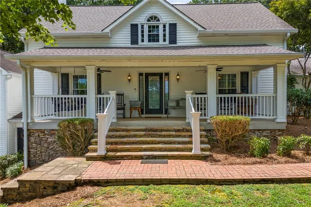 a living room with furniture kitchen view and a large window