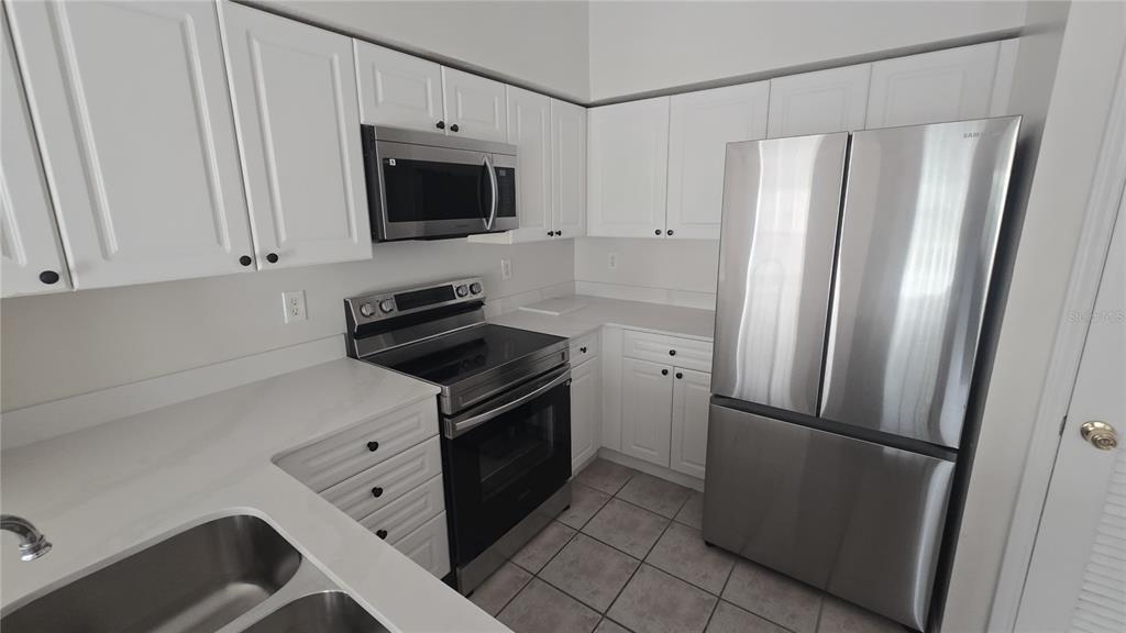791 Celebration Avenue, Unit 791 Celebration, FL 34747 - Photo 9 of 27 a kitchen with stainless steel appliances a refrigerator stove and cabinets