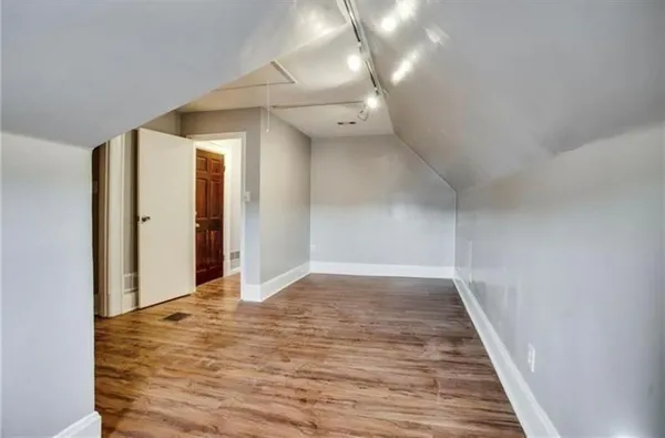 a view of empty room with wooden floor