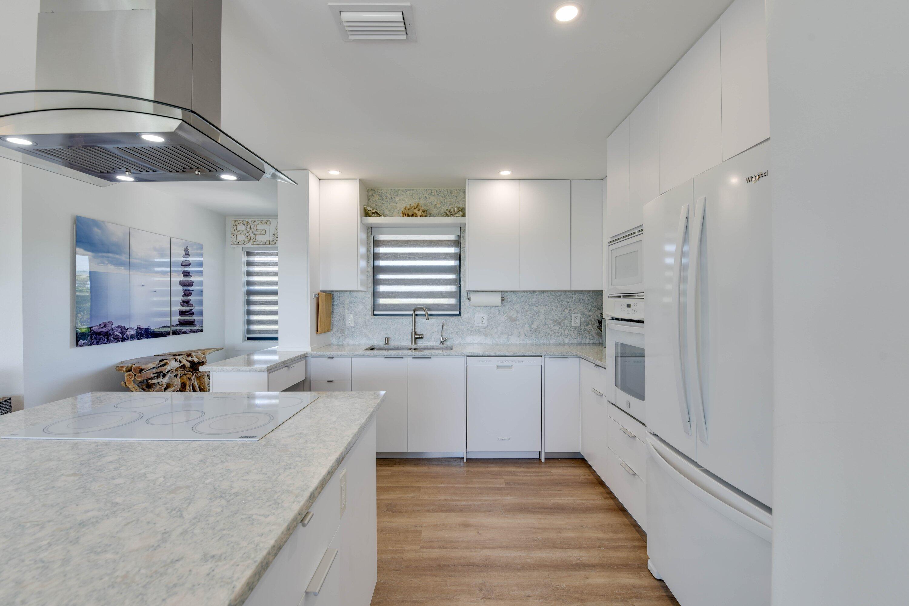 1422 Boca Chica Road Key West, FL 33040 - Photo 16 of 54 a large white kitchen with a sink and dishwasher a stove top oven with wooden floor